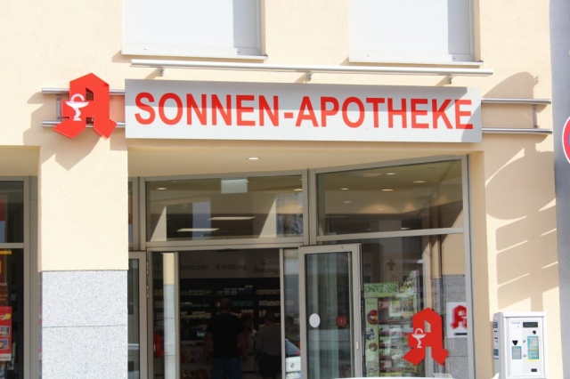 Apotheken Werbung Leuchtreklame an gelber Fassade